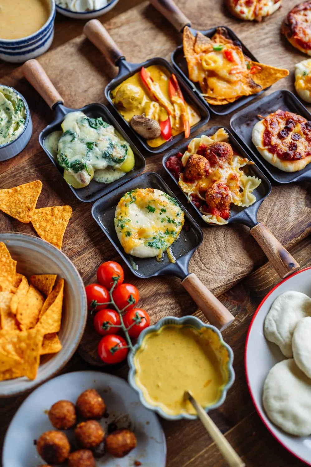 Goldbraun geschmolzener Raclette-Käse in einem Pfännchen, bereit zum Genießen