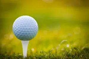 Golfball auf dem Tee mit malerischer Dünenlandschaft des Golfclub Budersand auf Sylt
