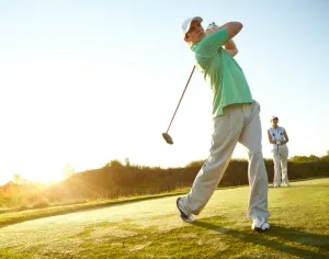 Golfer schlägt Ball auf einem Links Course in St. Peter-Ording mit Blick auf die Nordsee