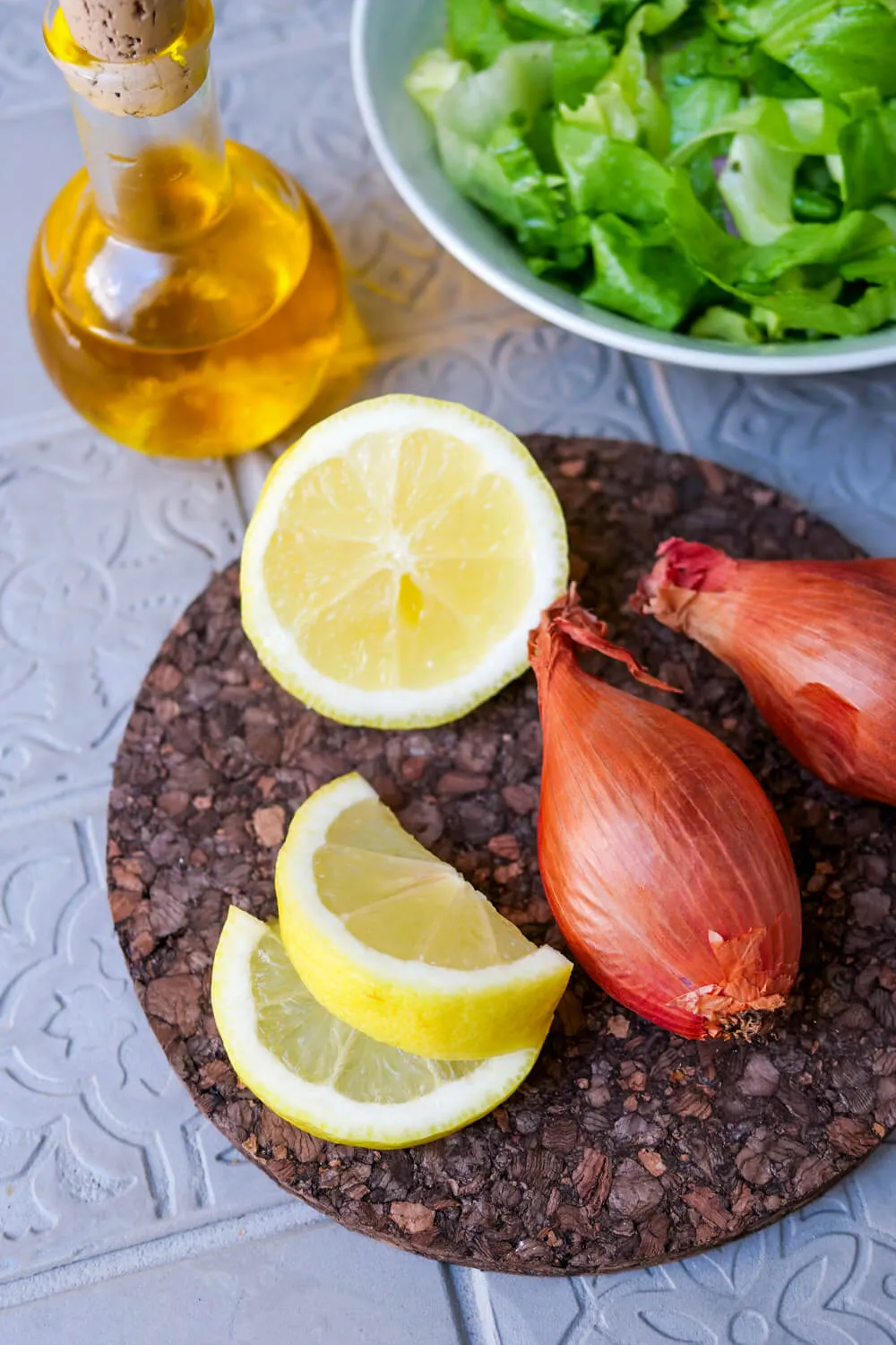 Grundzutaten für ein Endiviensalat Dressing: frische Zitrone, feine Schalotten, Olivenöl und ein ganzer Endiviensalat.