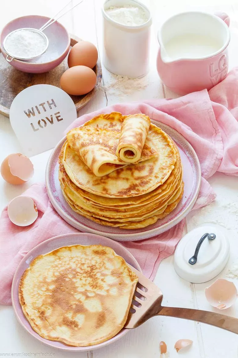 Grundzutaten für einen klassischen Pfannkuchenteig: Mehl, Eier, Milch, Mineralwasser und Öl bereit zum Anrühren.