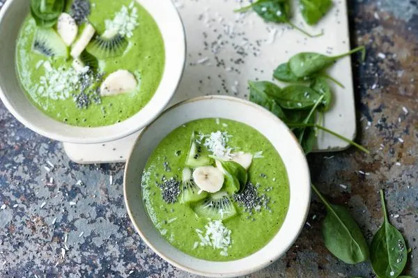 Grüne Smoothie-Bowl mit frischen Früchten und Kokosraspeln
