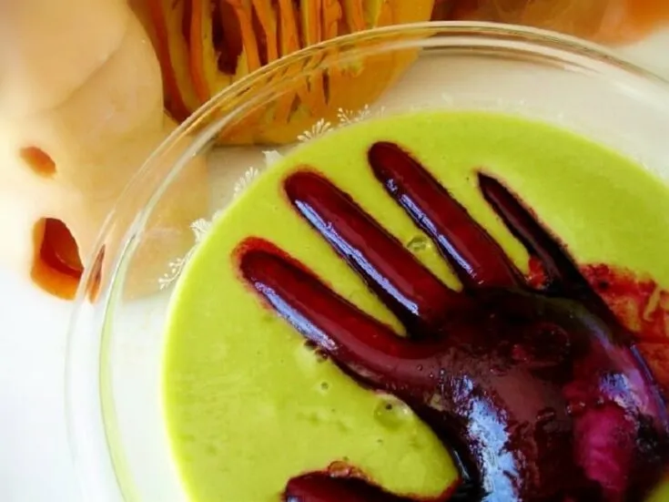 Grüner Hexenbrau-Halloween-Smoothie mit einer gruseligen Monsterhand, vegan und gesund