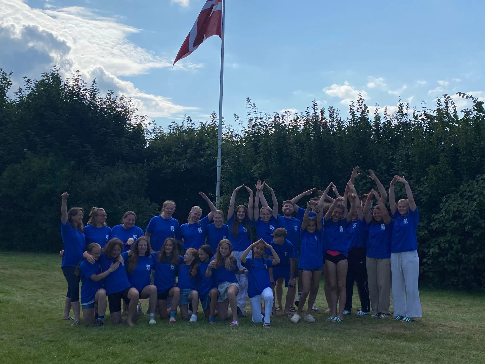 Gruppe von Turnerinnen und Trainern vor einem Haus am Strand in Midskow, Dänemark, nach dem Trainingslager