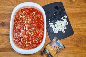 Hackfleischsoße und Kritharaki vermengen