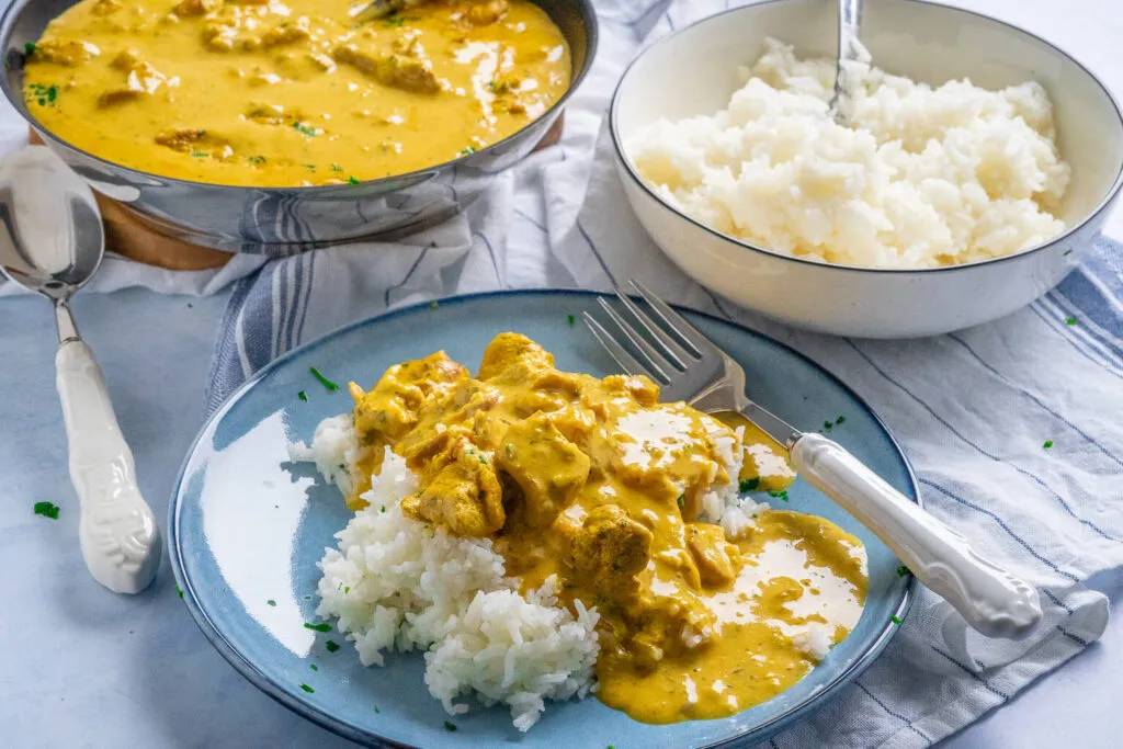 Hähnchen-Curry-Geschnetzeltes in einer Pfanne, fast fertig, mit cremiger Soße