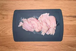 Hähnchenbrustfilet wird für die Fajitas in gleichmäßige, schmale Streifen geschnitten