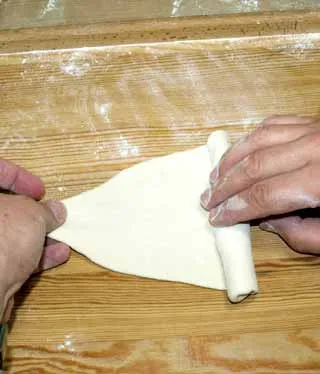 Halbmondförmige Hörnchen Brötchen auf einem Backblech, vor dem Backen