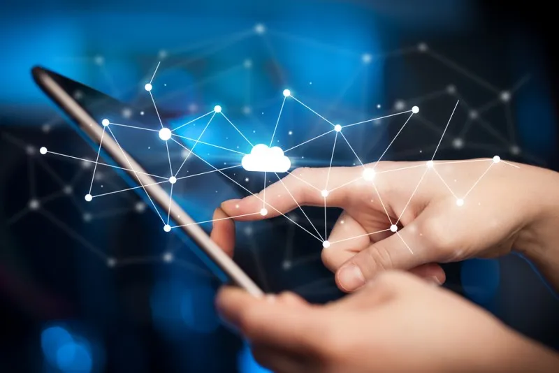 Hände, die ein Tablet bedienen. Ddarüber schwebt die schematische Darstellung einer virtuellen Cloud.