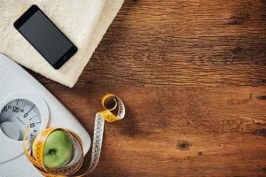 Hände halten ein Tablet mit Gewichtsverlaufsgrafik, zeigt Fortschritt beim 5 Kilo abnehmen