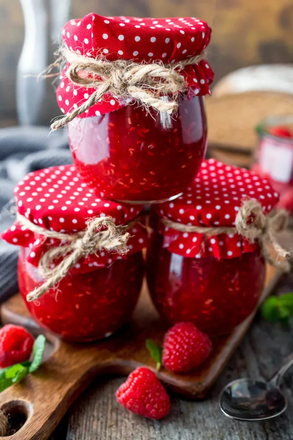 Handgemachte Himbeermarmelade in mehreren Einmachgläsern, ein Zeichen für hausgemachten Genuss und Haltbarkeit.