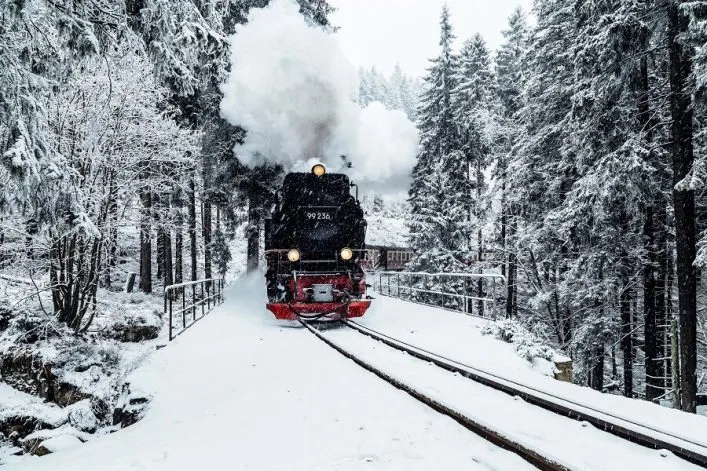 Harzer Schmalspurbahn mit Dampflok im verschneiten Winterwald, ein Highlight der Harz Reisetipps