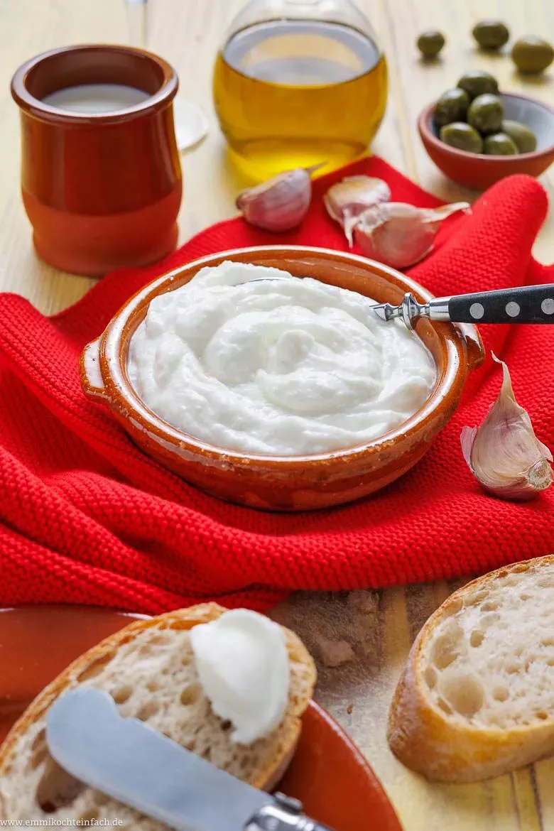Hausgemachte Aioli ohne Ei auf frischem Baguette, bereit zum Genießen als einfacher Dip.