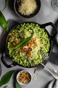 Hausgemachte Röstzwiebeln auf traditionellen Bärlauch-Käsespätzle, ein Highlight der deutschen Küche.