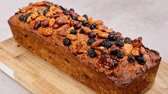 Hausgemachter Frucht-Nuss-Kuchen mit Puderzucker bestreut