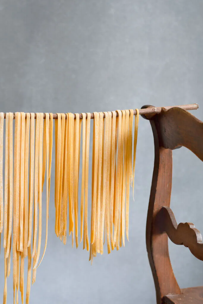 Hausgemachter Nudelteig auf Holzbrett bereit zum Ausrollen