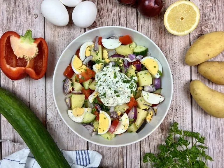 Hausgemachter Sommerlicher Kartoffelsalat mit Ei, Gurke und frischen Kräutern