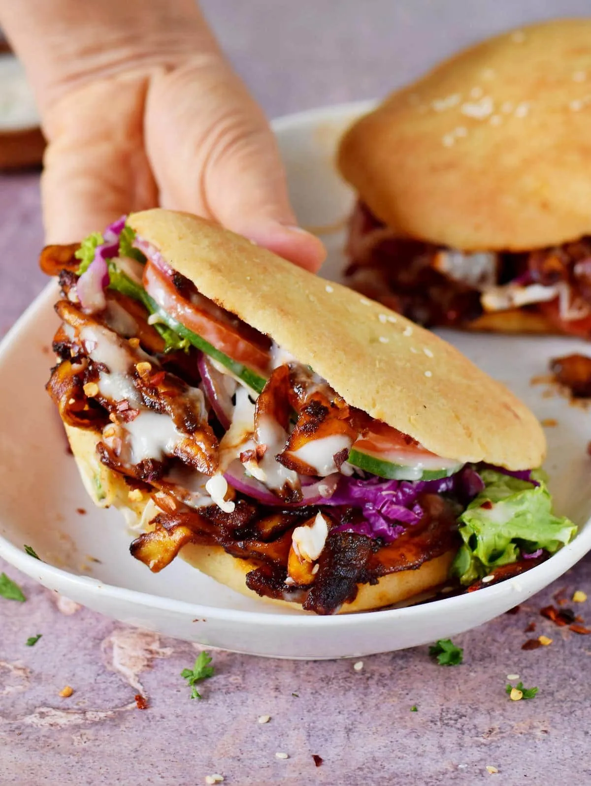 Hausgemachter veganer Döner Kebab mit gewürzter Jackfruit, Salat und Knoblauch-Joghurt-Sauce im Pitabrot, eine gesunde Alternative zum Imbiss.