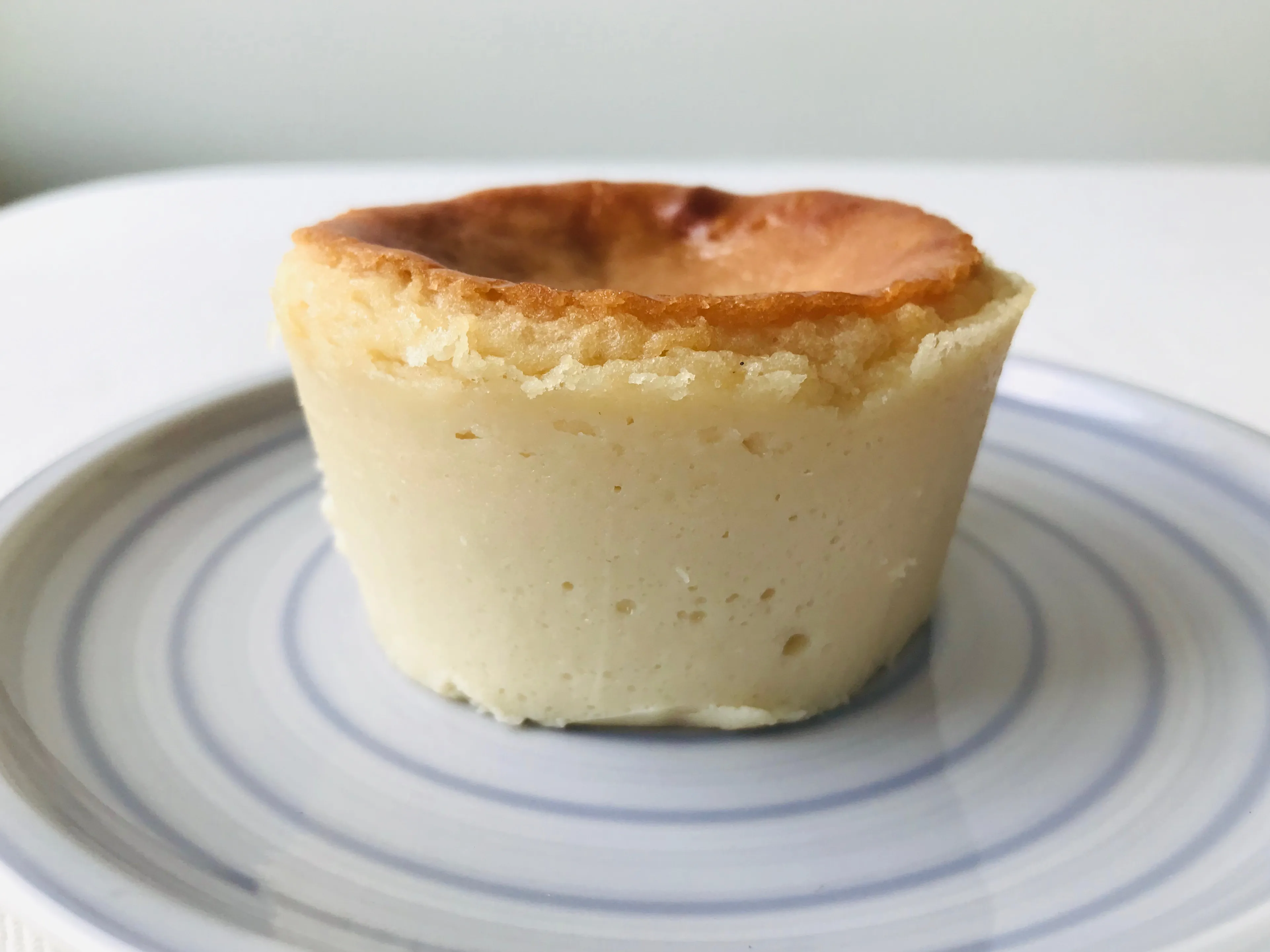 Hellgelbe, goldbraun gebackene vegane Käsekuchenmasse in einem Schälchen, leicht angebräunt an der Oberfläche