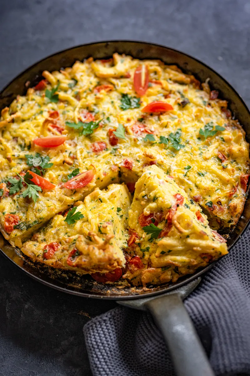 Herzhafte Spätzle-Frittata mit Käse und Kräutern, goldbraun gebacken, als idealer Silvester-Snack