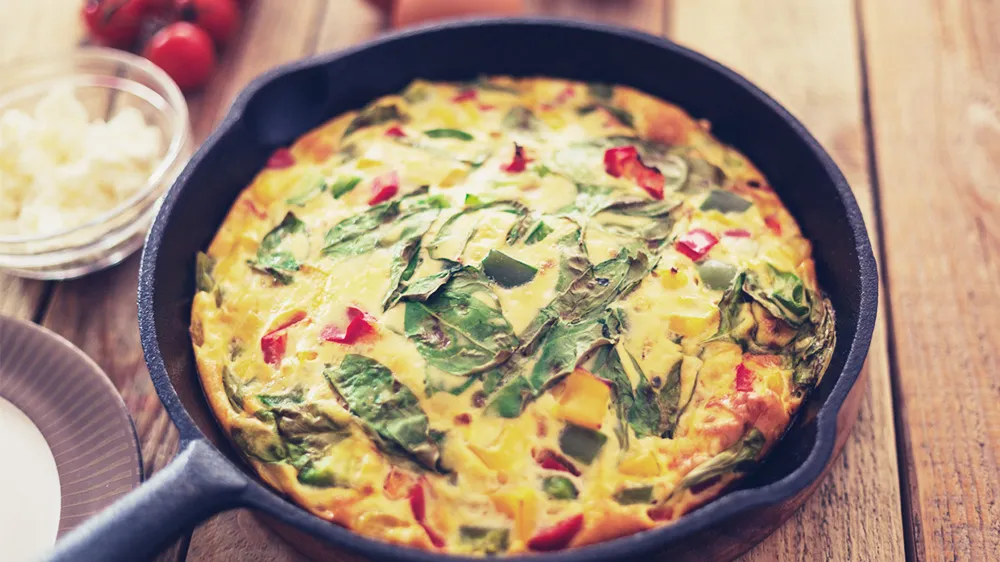 Herzhafte Tomaten-Spinat-Frittata mit Feta in einer Pfanne als Low-Carb-Option