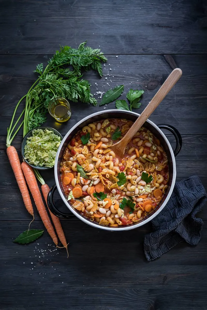Herzhafte Wirsing Minestrone in einer Schale, garniert mit frischen Kräutern und Parmesan