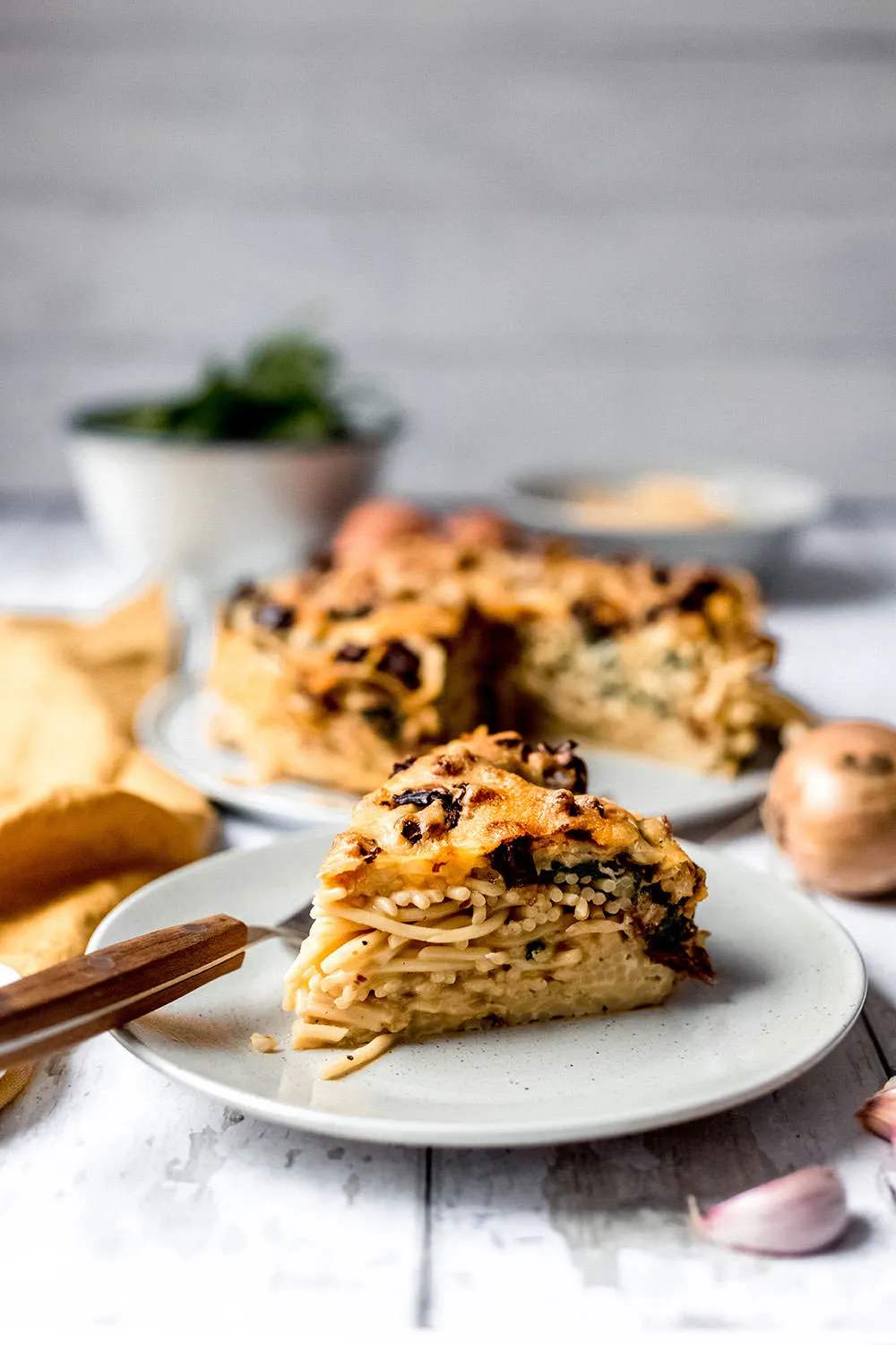 Herzhafter Spaghetti-Kuchen mit frischem Spinat und getrockneten Tomaten.