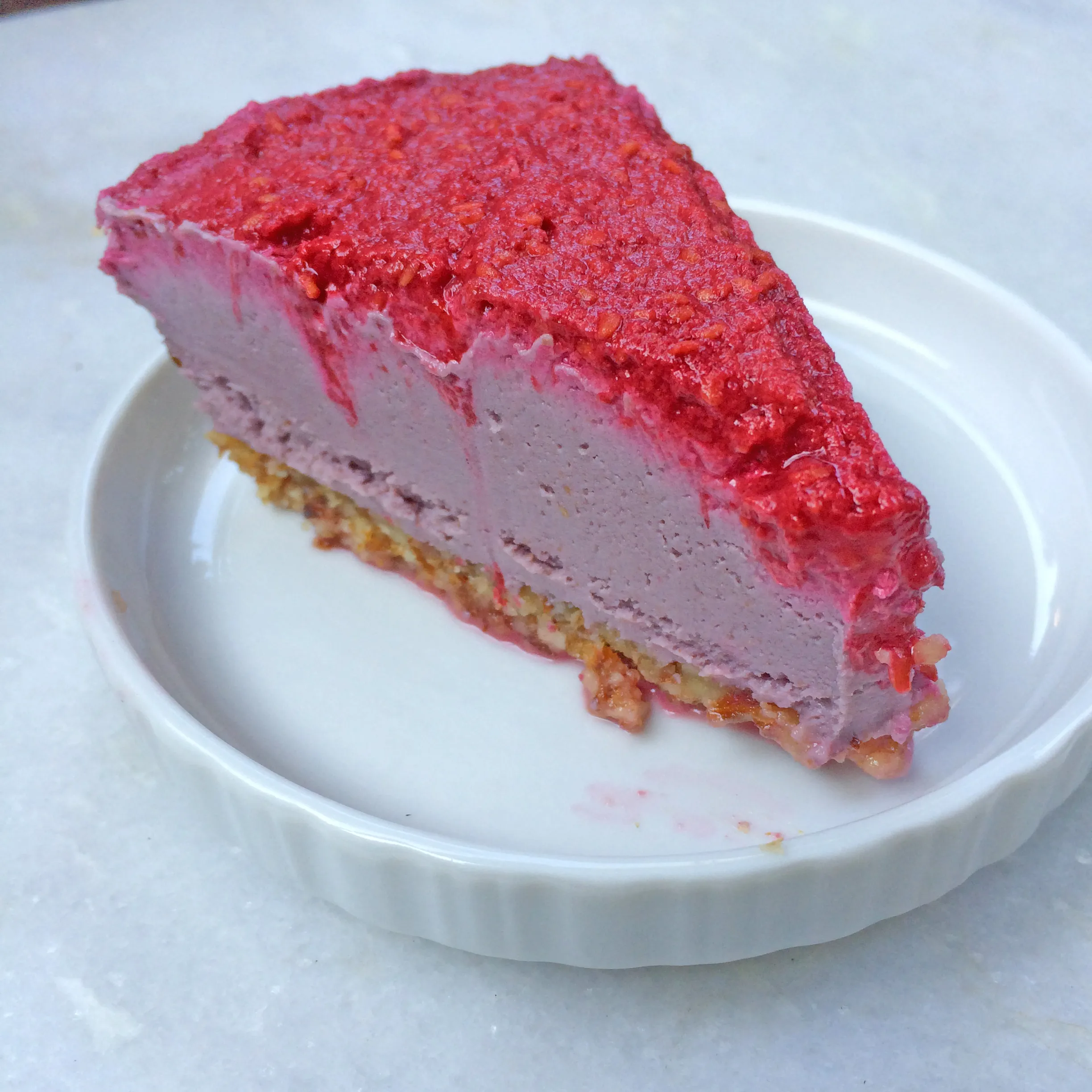 Himbeer-Cashew-Kuchen ohne Zucker und Mehl auf einem Teller mit Gabel