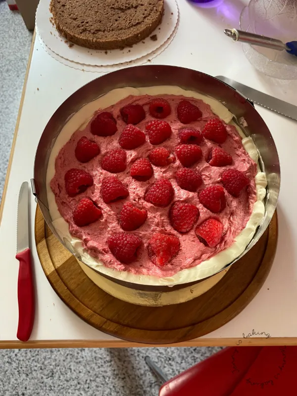 Himbeer-Schokofüllung für Hochzeitstorte, stabilisiert durch einen Tortenring für gerade Schichten.