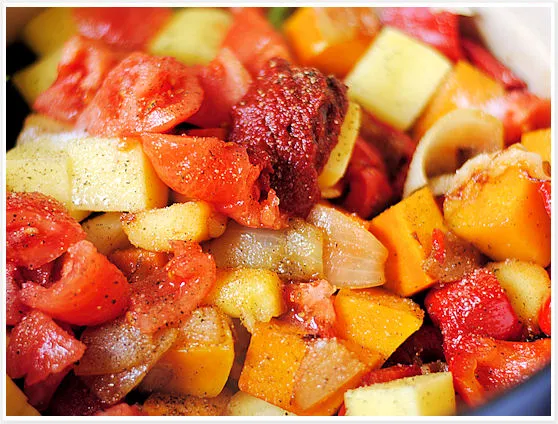 Hinzufügen von Kartoffeln, Tomaten und Tomatenmark zur Ratatouille-Mischung