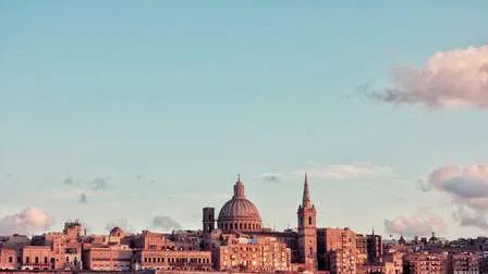Historische Gebäude von Valletta, der Hauptstadt Maltas, bei Sonnenuntergang, mit Blick auf das Meer und den Hafen.