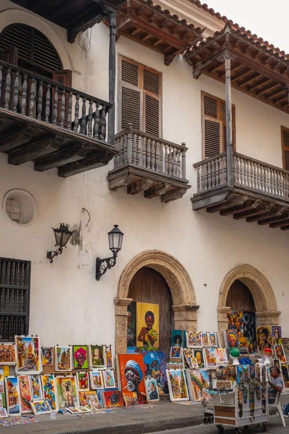 Historische Hausfassade mit verzierten hölzernen Balkonen und vielen bunten Gemälden und Souvenirs davor