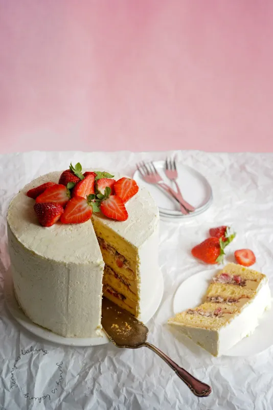 Hohe Erdbeer-Stracciatella-Torte mit Schokoladenstückchen.