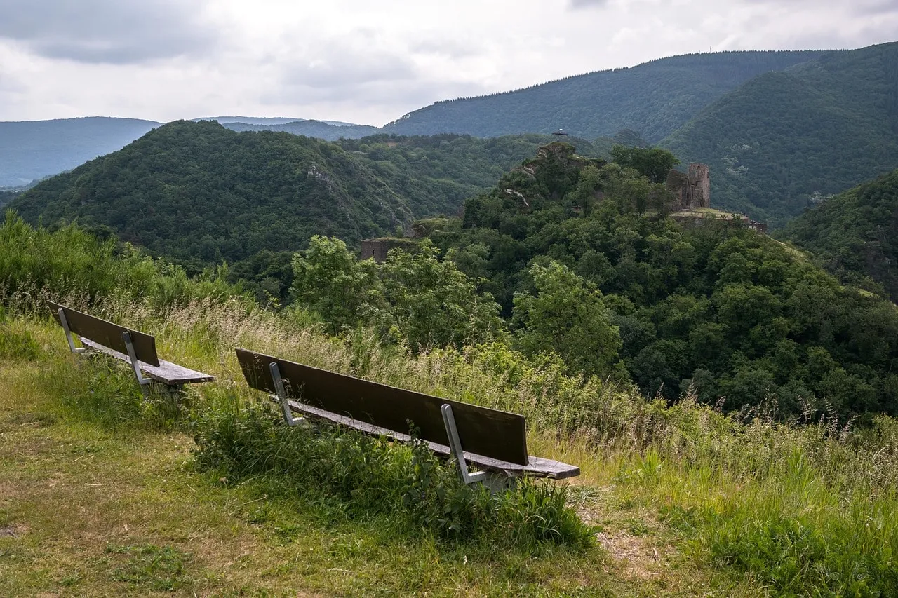Idyllische Landschaft der Eifel mit grünen Hügeln und traditionellen Dörfern, ideal für Wanderurlaub.