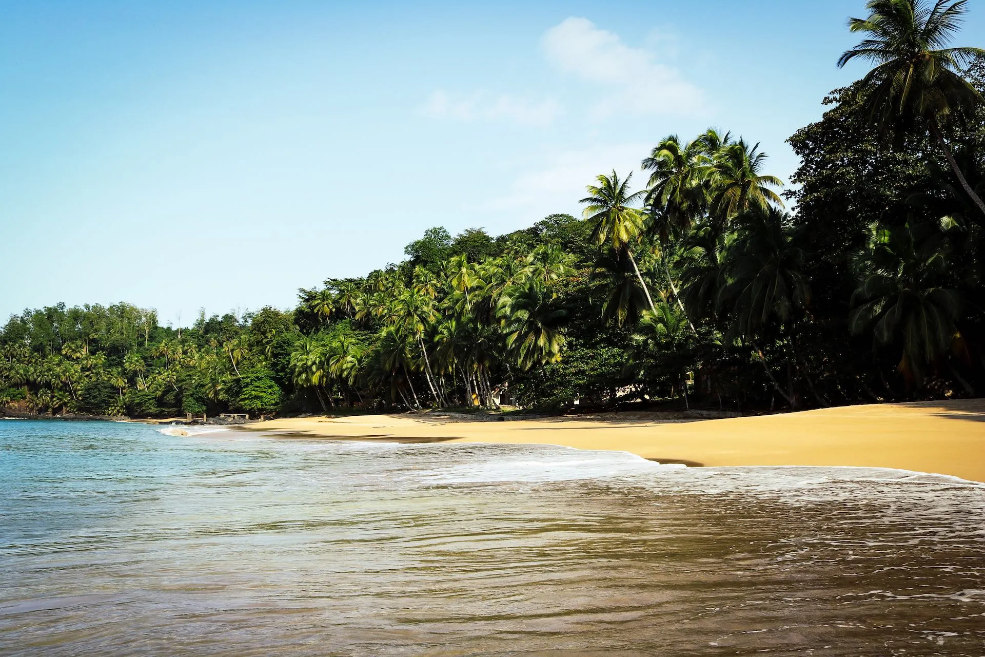 Idyllischer Strand auf Príncipe in Afrika mit Palmen, weißem Sand und klarem, türkisblauem Wasser
