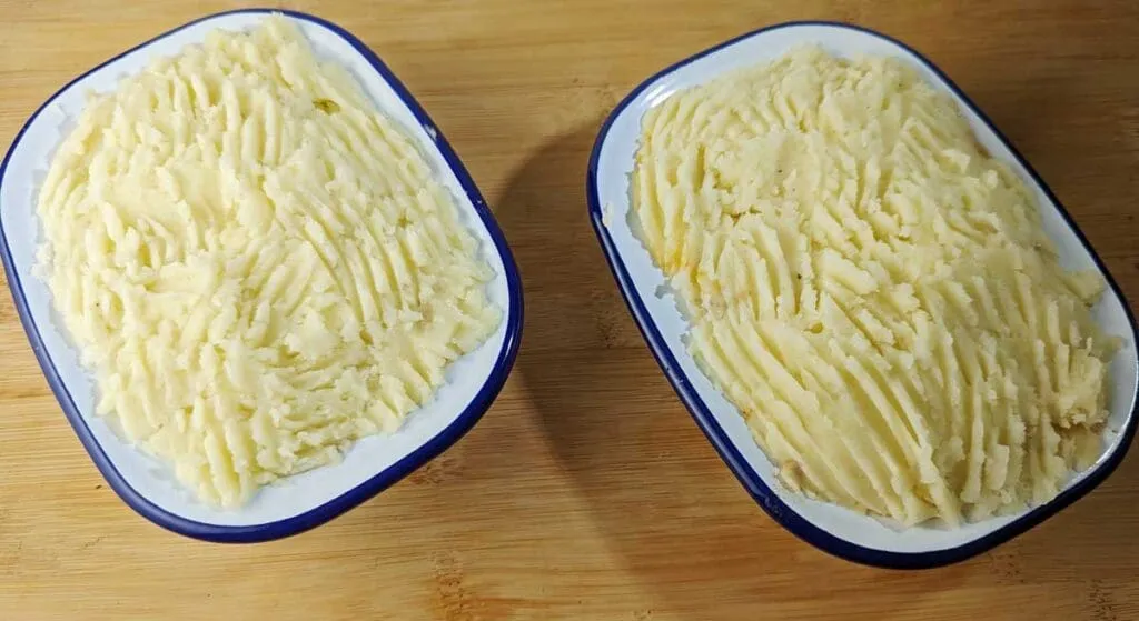 Individuelle Shepherd's Pies in Auflaufformen, vorbereitet zum Backen im Ofen oder der Heißluftfritteuse