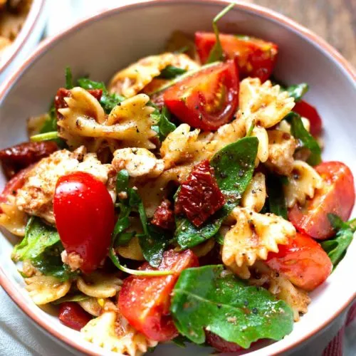 Italienischer Nudelsalat mit Tomaten, Rucola und Mozzarella, ein beliebtes Gericht auf deutschen Partys.