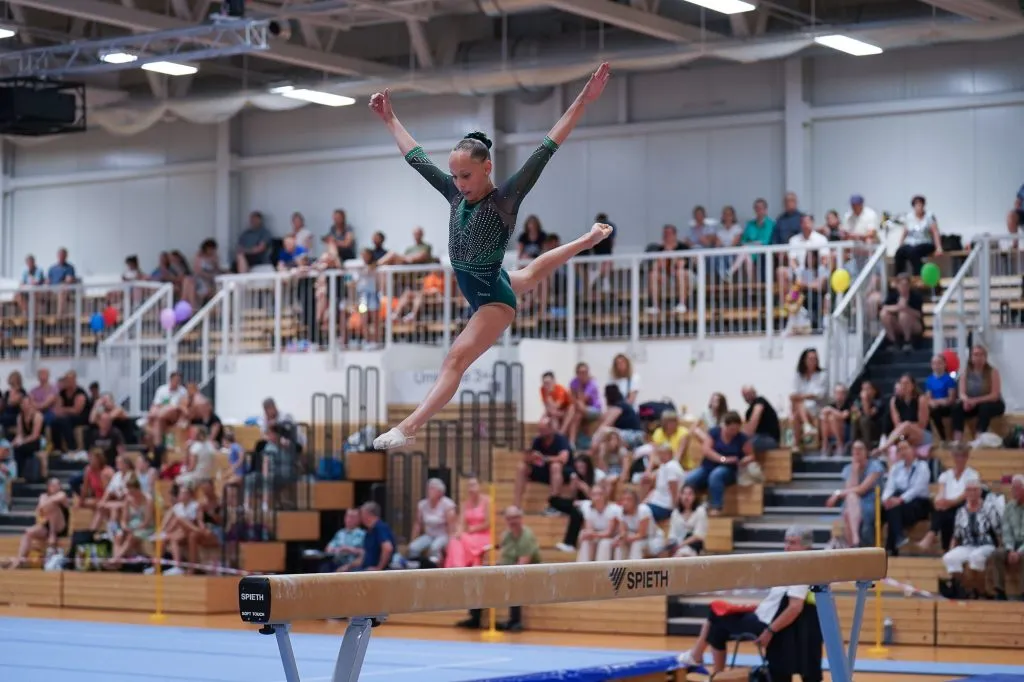 Junge Turnerin bei einer Bodenübung im Geräteturnen.