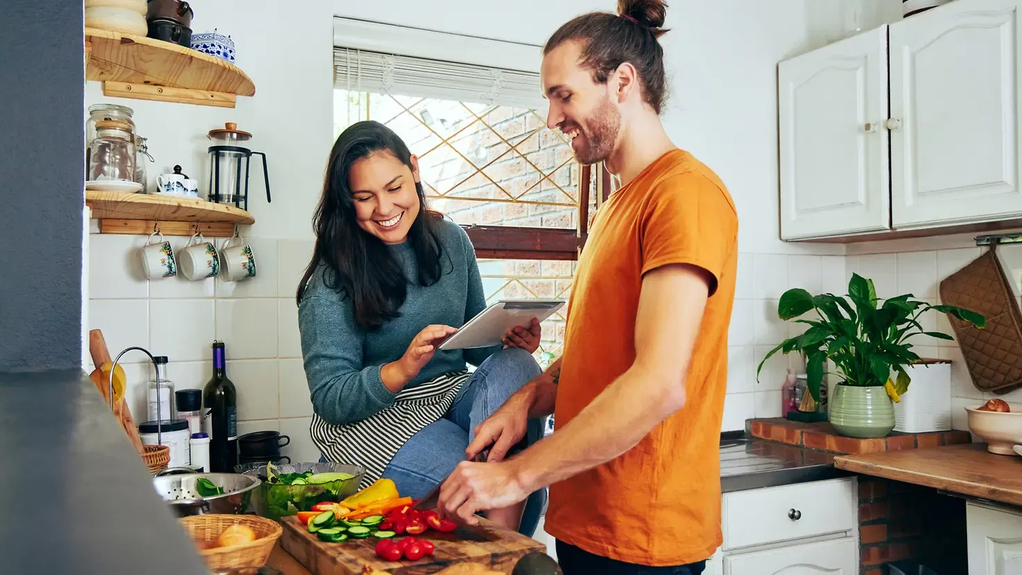 Junges Paar bereitet gesunde, ballaststoffreiche Mahlzeit mit frischem Gemüse zu als Alternative zum Apfelessig-Abnehmtrend