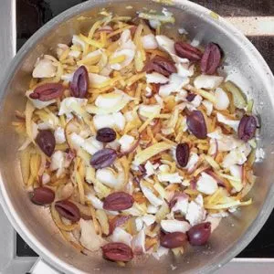 Kabeljau, Oliven und gebratenes Gemüse in einer Pfanne, vermengt für Bacalhau à Brás.