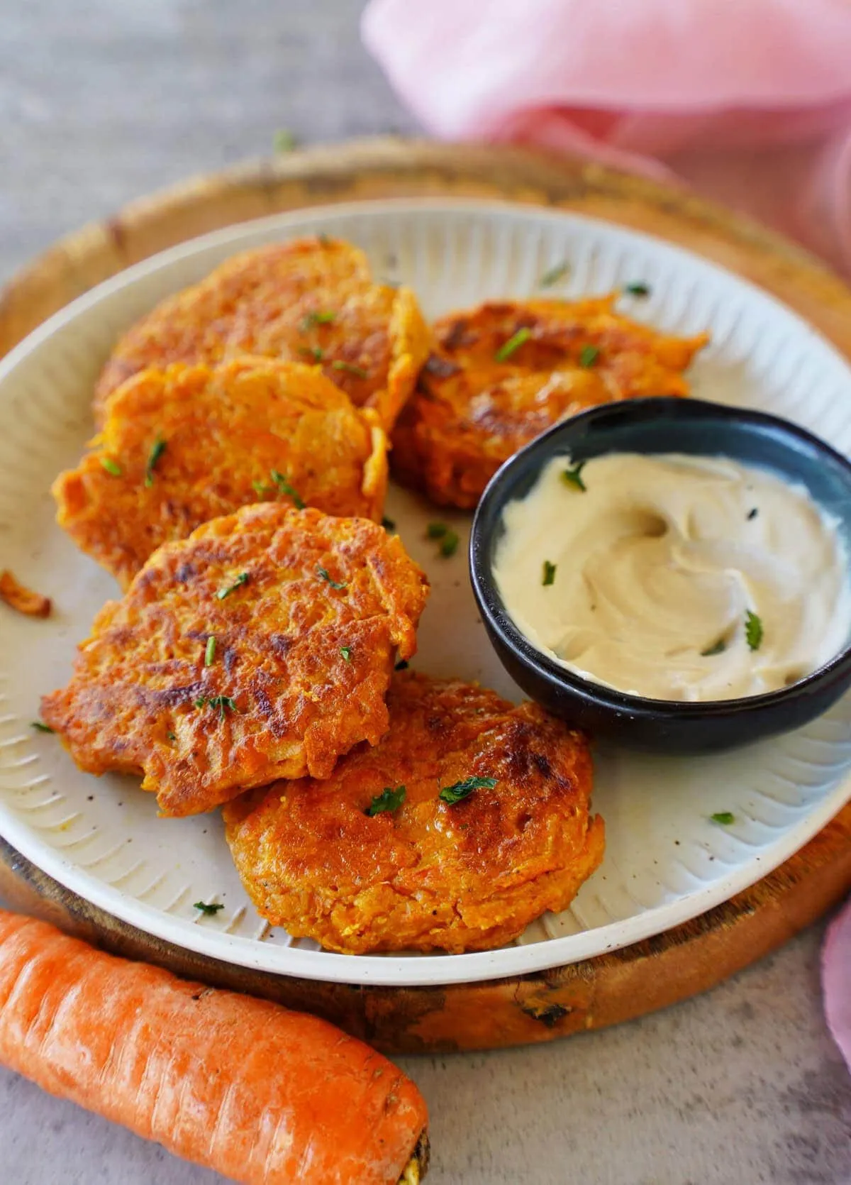 Karotten-Bratlinge auf einem Teller mit Dip, arrangiert