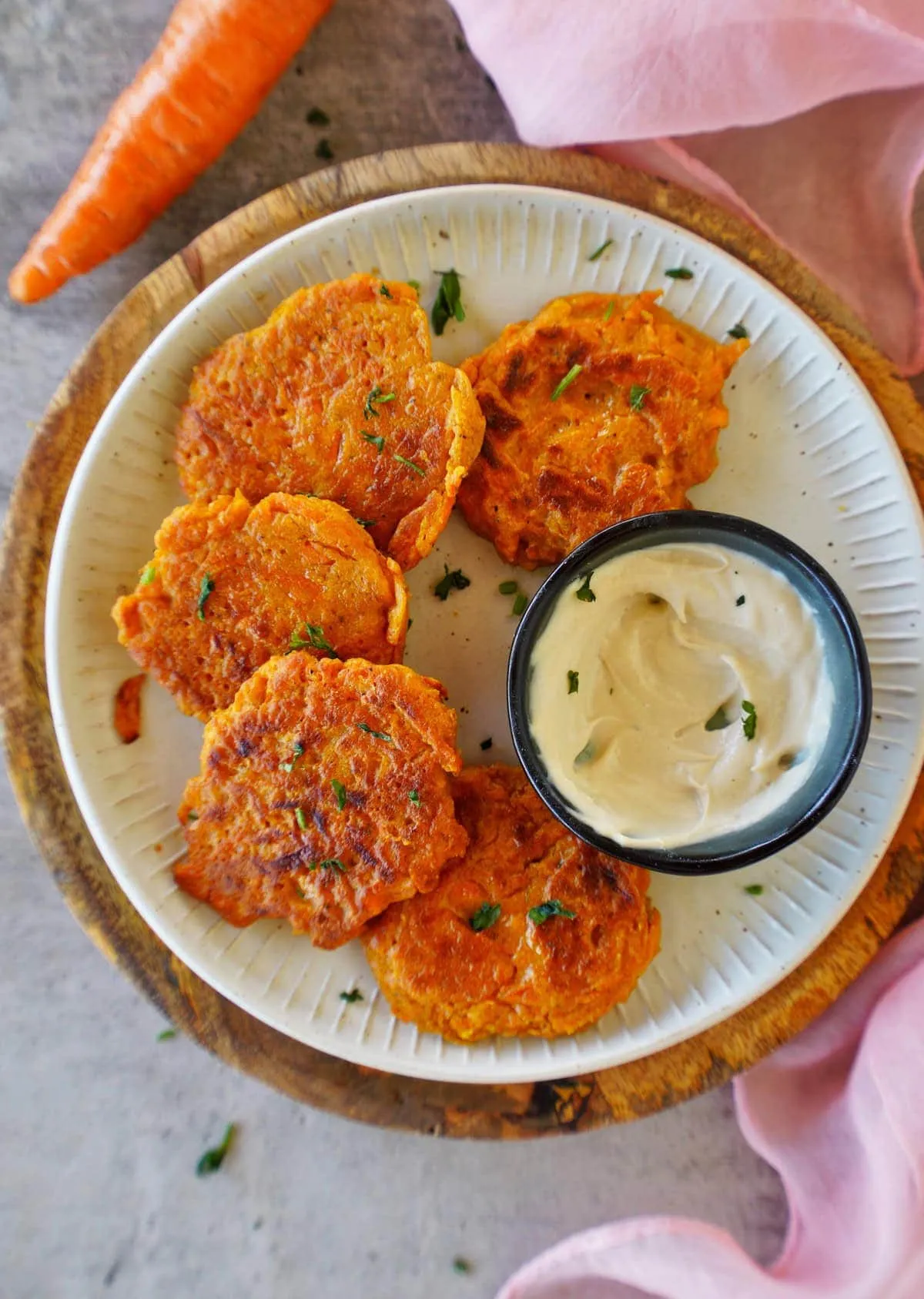 Karotten-Bratlinge auf Teller mit Dip von oben