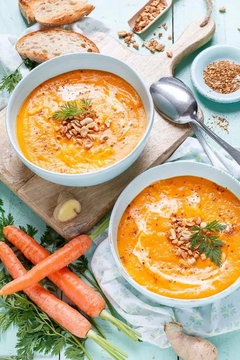 Karotten Ingwer Suppe in einer Schüssel mit frischen Kräutern, perfekt für ein gesundes Mittag- oder Abendessen.