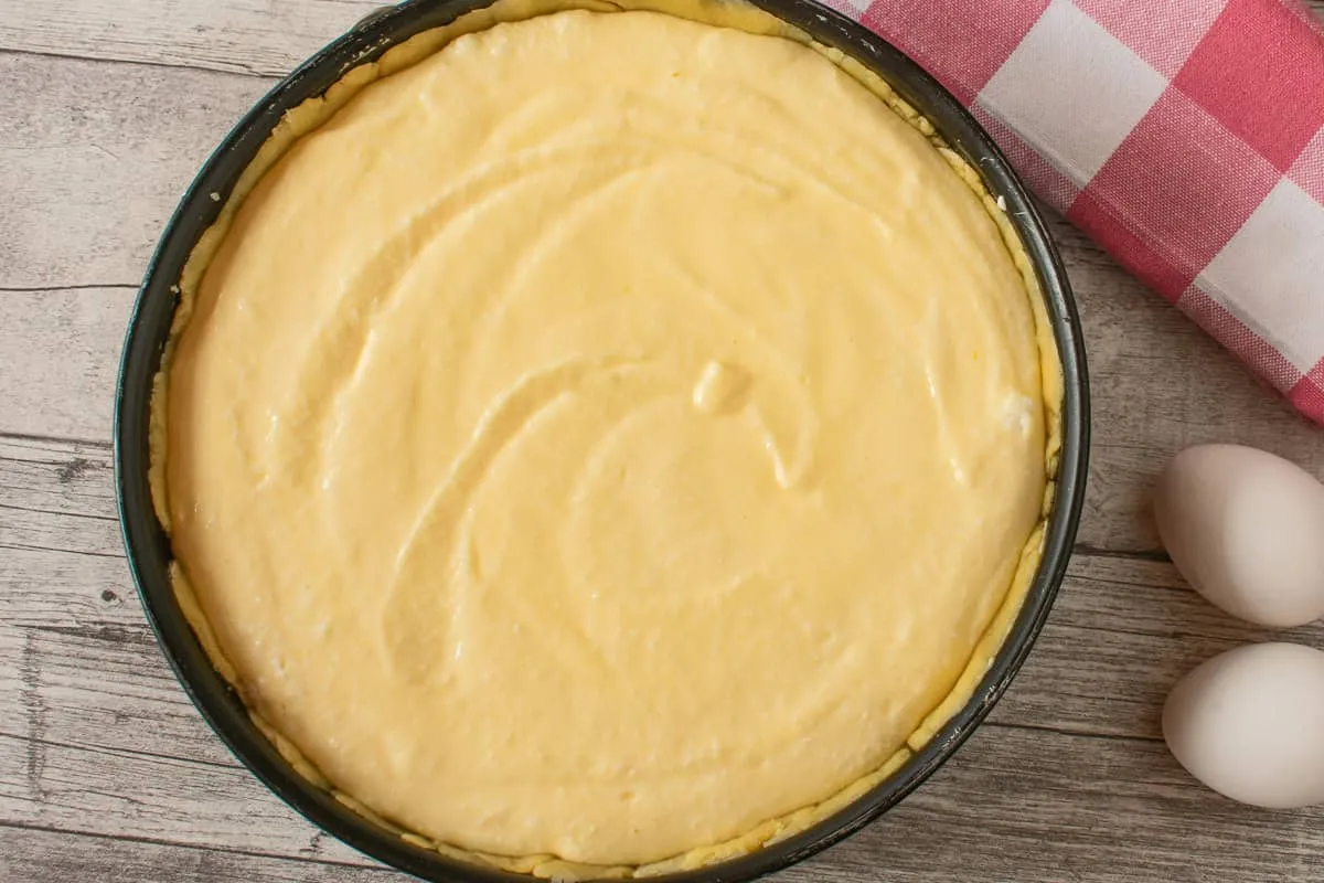 Käsekuchenfüllung im Mürbeteigboden kurz vor dem Backen