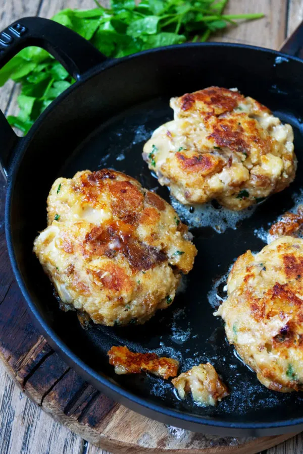 Kaspressknödel auf einem Teller angerichtet, begleitet von einem frischen Salat