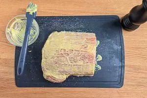 Kassler Bratenstück gleichmäßig mit Senf einreiben für intensiveren Geschmack.