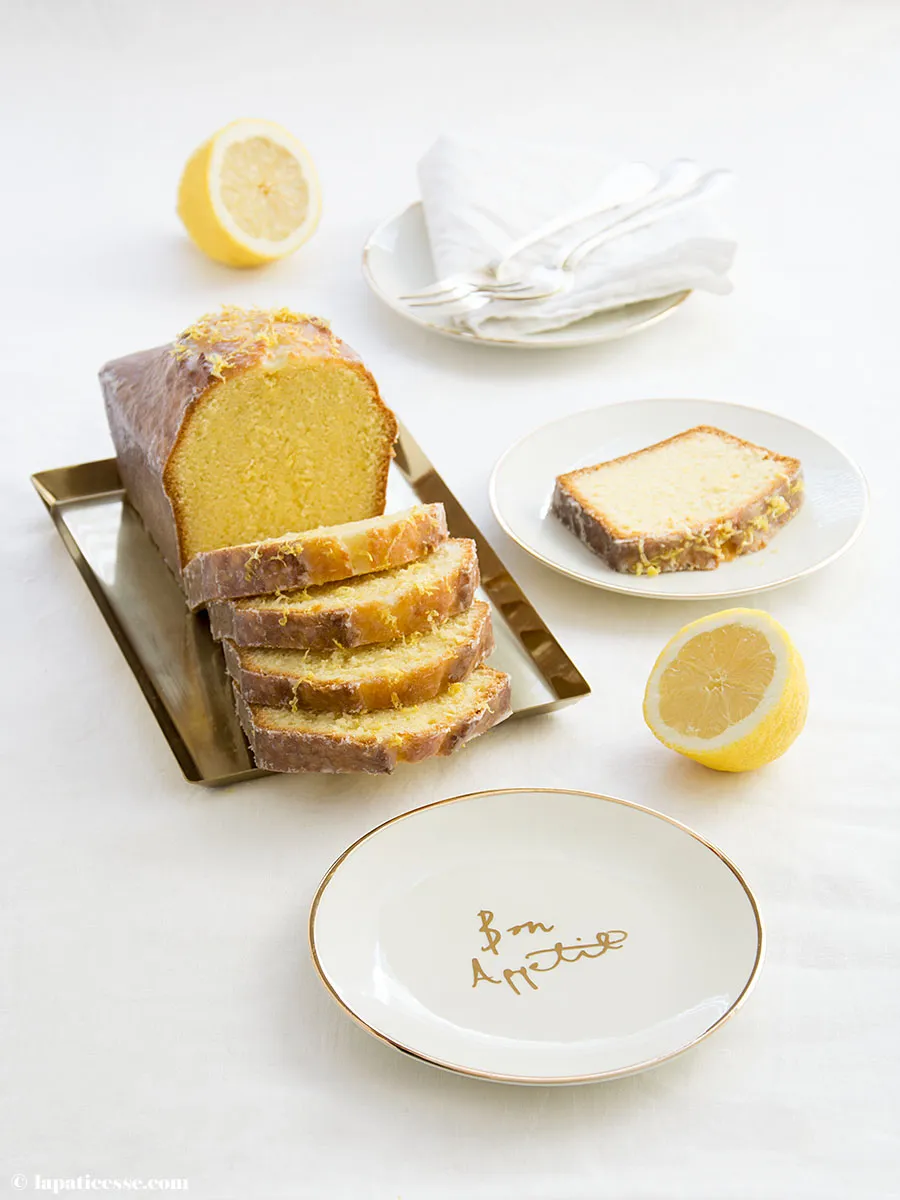 Kastenkuchen mit Zitronenglasur und frischem Zitronenabrieb auf Holzbrett