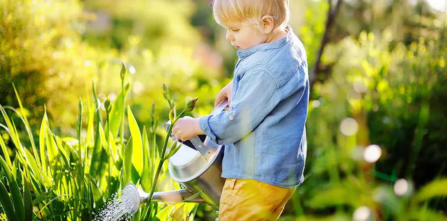 Kind pflegt einen kleinen Kräutergarten im Freien, entdeckt die Vielfalt der Natur im Frühling