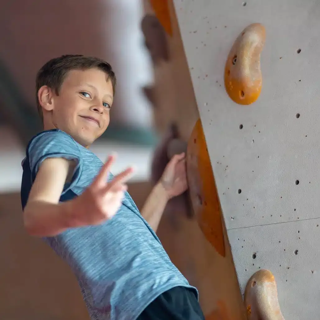 Kind während der Osterferien in den Ostercamps beim Bouldern
