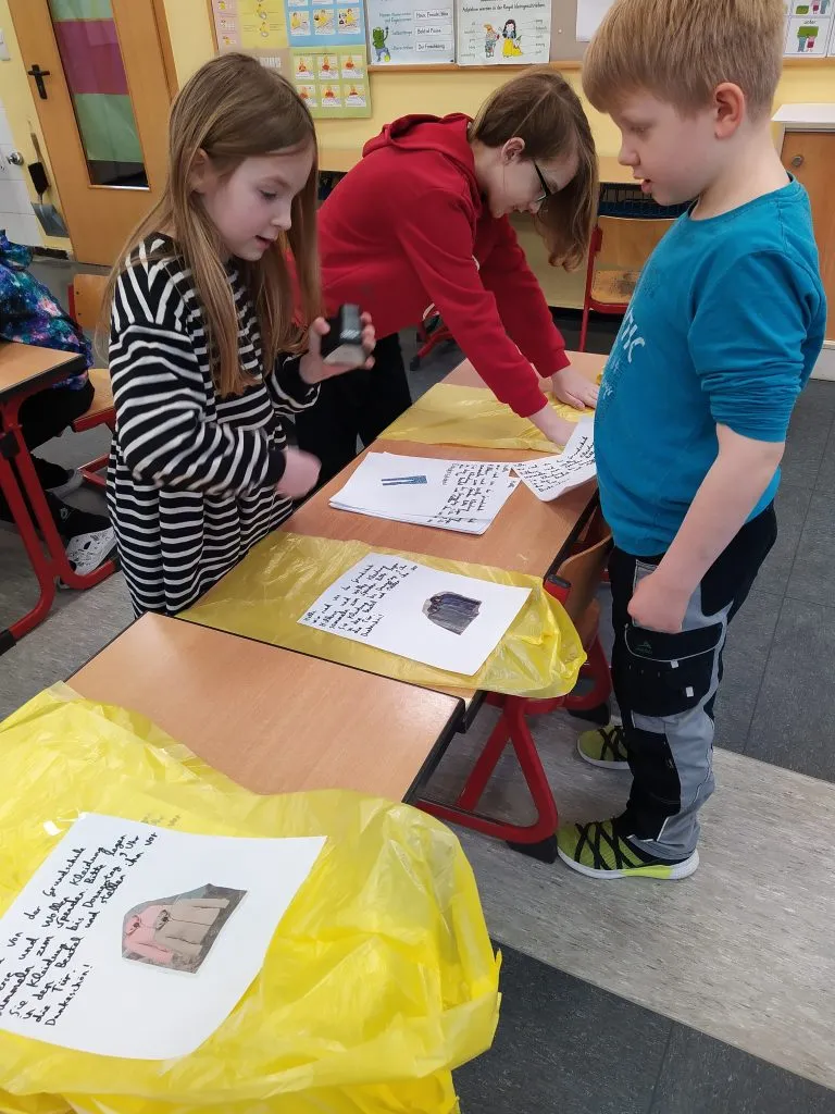 Kinder organisieren gesammelte Kleidung für die Spende an bedürftige Familien im Rahmen ihrer Projektwoche.